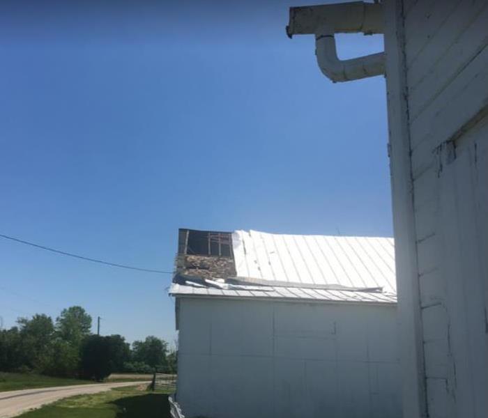 damaged barn roof caused by a storm